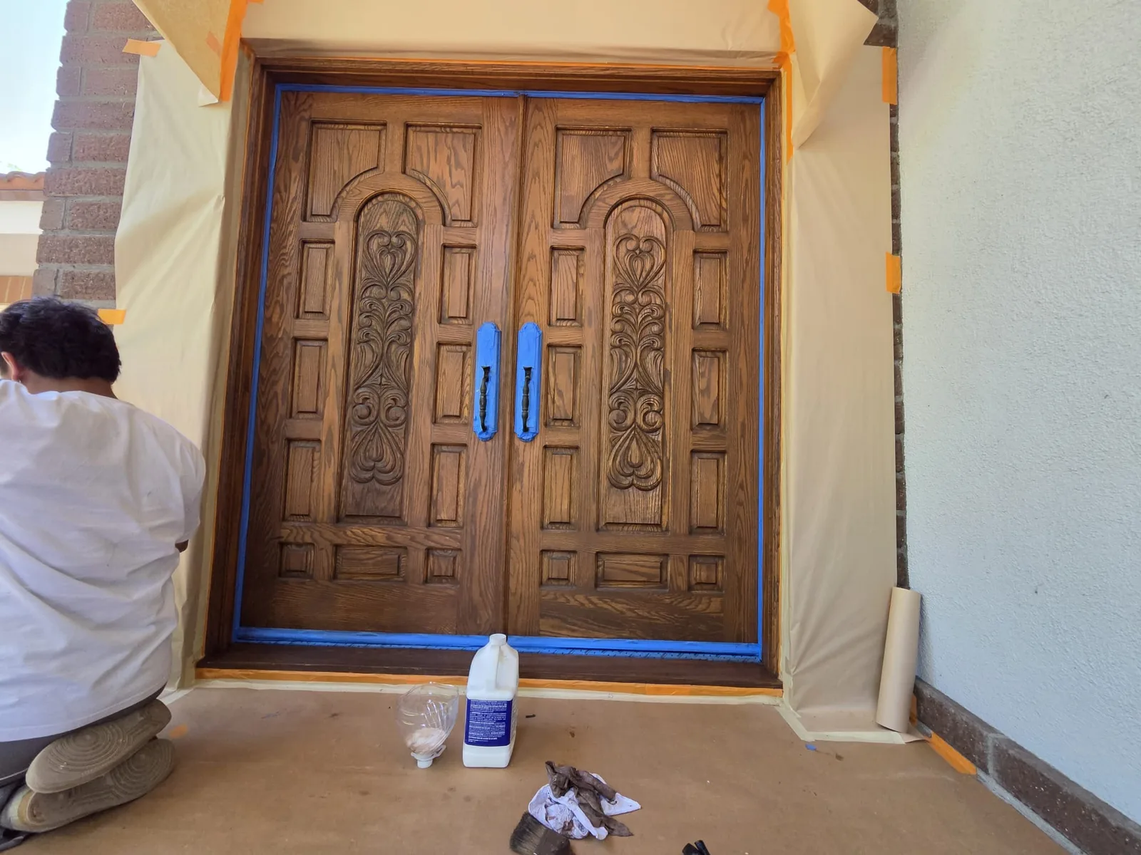 Carved wood entry doors being hand finished in a warm stain.