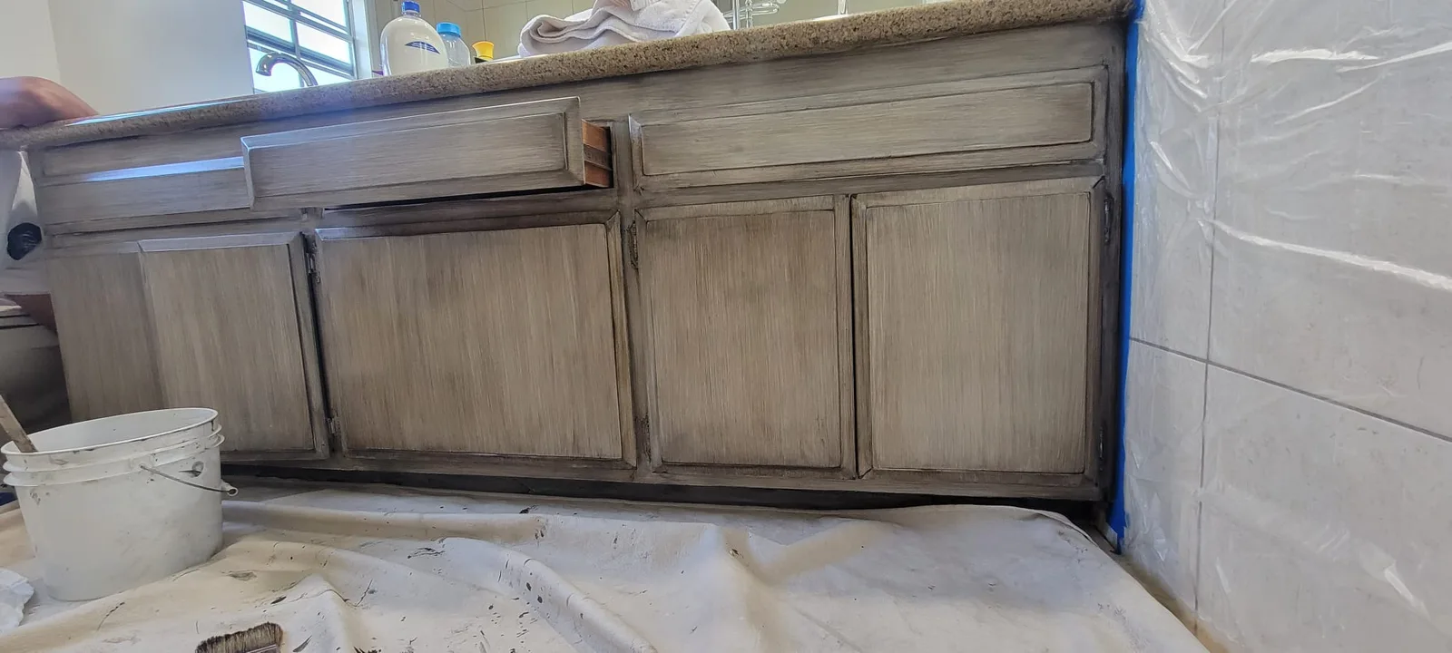 Bathroom cabinetry hand-glazed to read as natural wood grain.