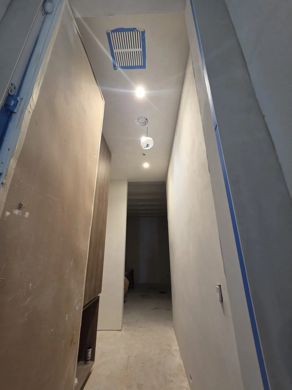 Long plaster corridor finished in a soft, matte, mineral-style texture.